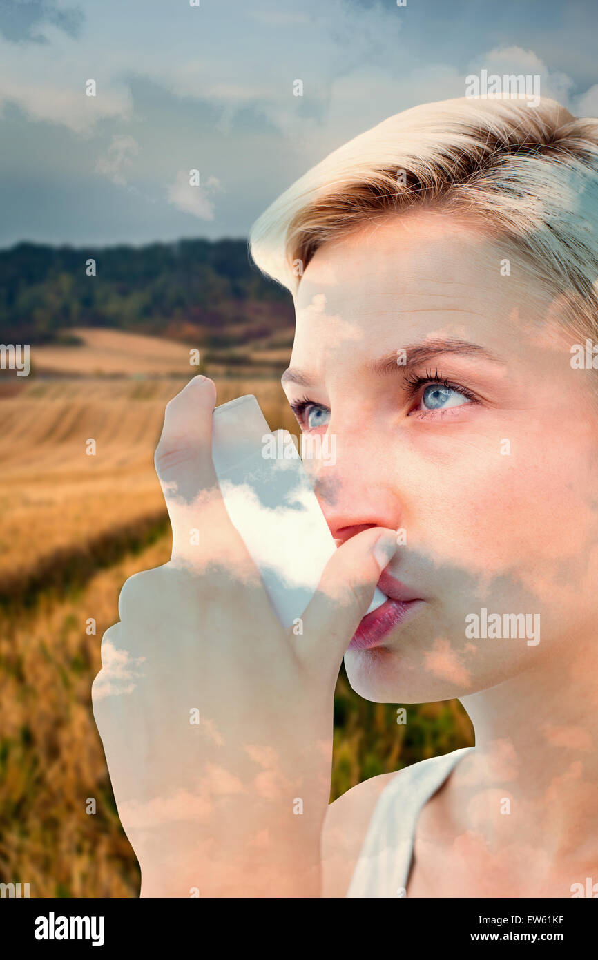 Immagine composita della donna bionda prendendo il suo inalatore Foto Stock