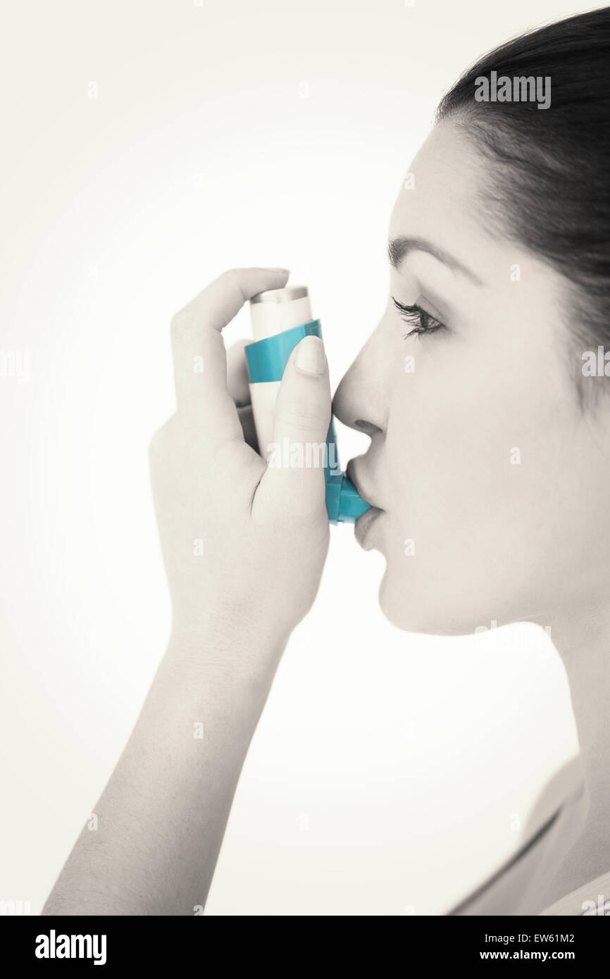 Donna che utilizza l'asma inalatore Foto Stock