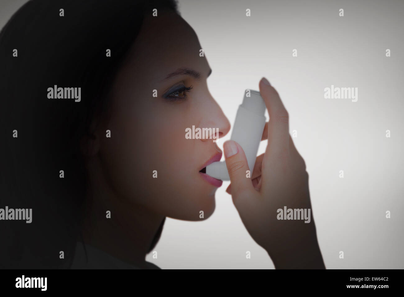 Immagine composita di bruna asmatici usando il suo inalatore Foto Stock