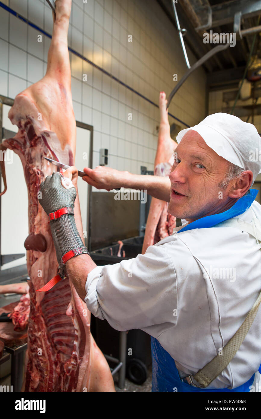 Macellaio di taglio di carne di maiale appeso alla macelleria in europa Foto Stock
