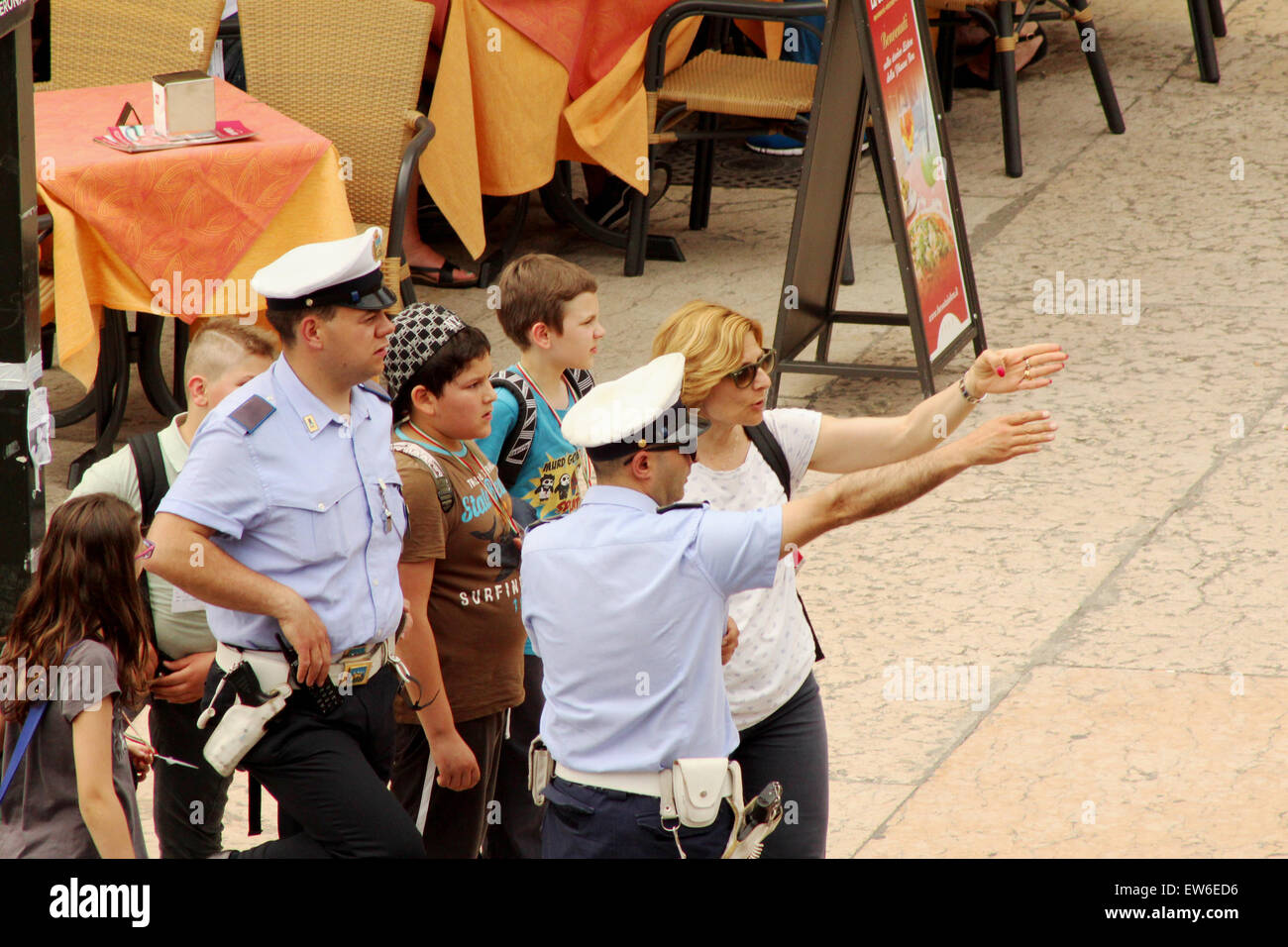 Persone che chiedono le direzioni da un funzionario di polizia a Verona Italia Foto Stock