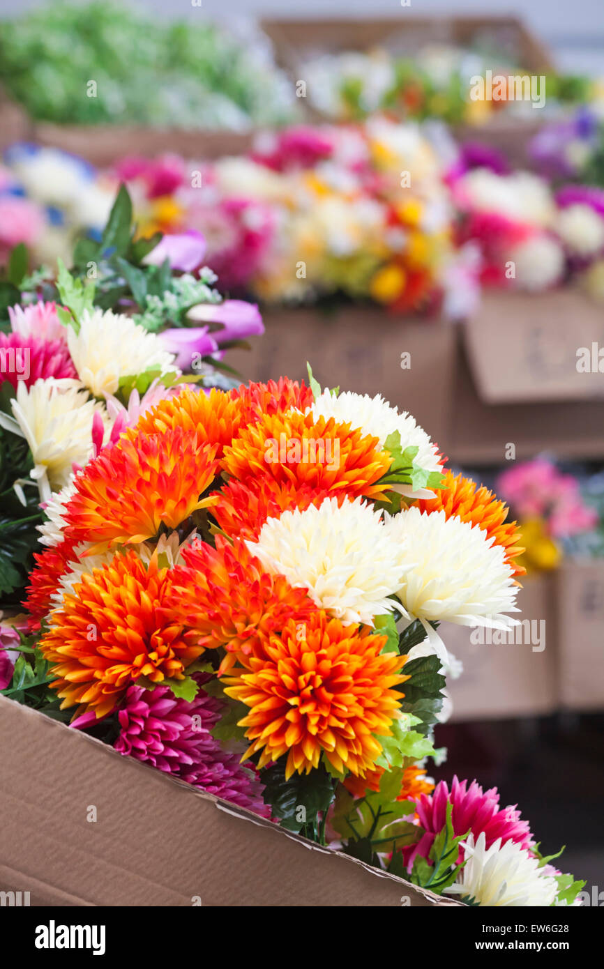 Materia plastica artificiale fiori sul mercato in stallo Dorchester Dorset, Regno Unito in giugno Foto Stock