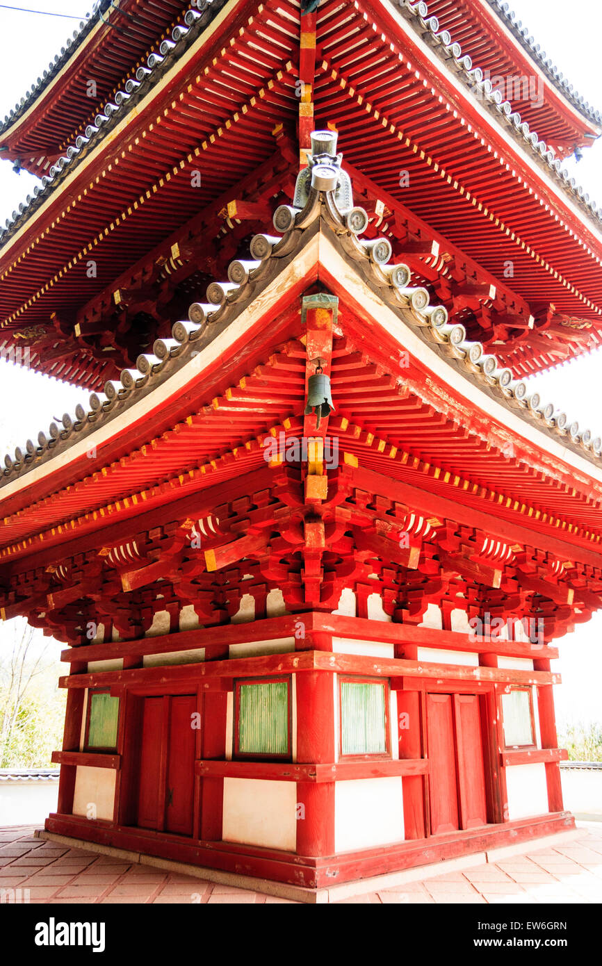 Giappone, Onomichi, Tempio Saikokuji. Angolo vista della pagoda a tre piani bianca, verde e vermiglio. Primo piano, guardando la struttura in legno. Foto Stock
