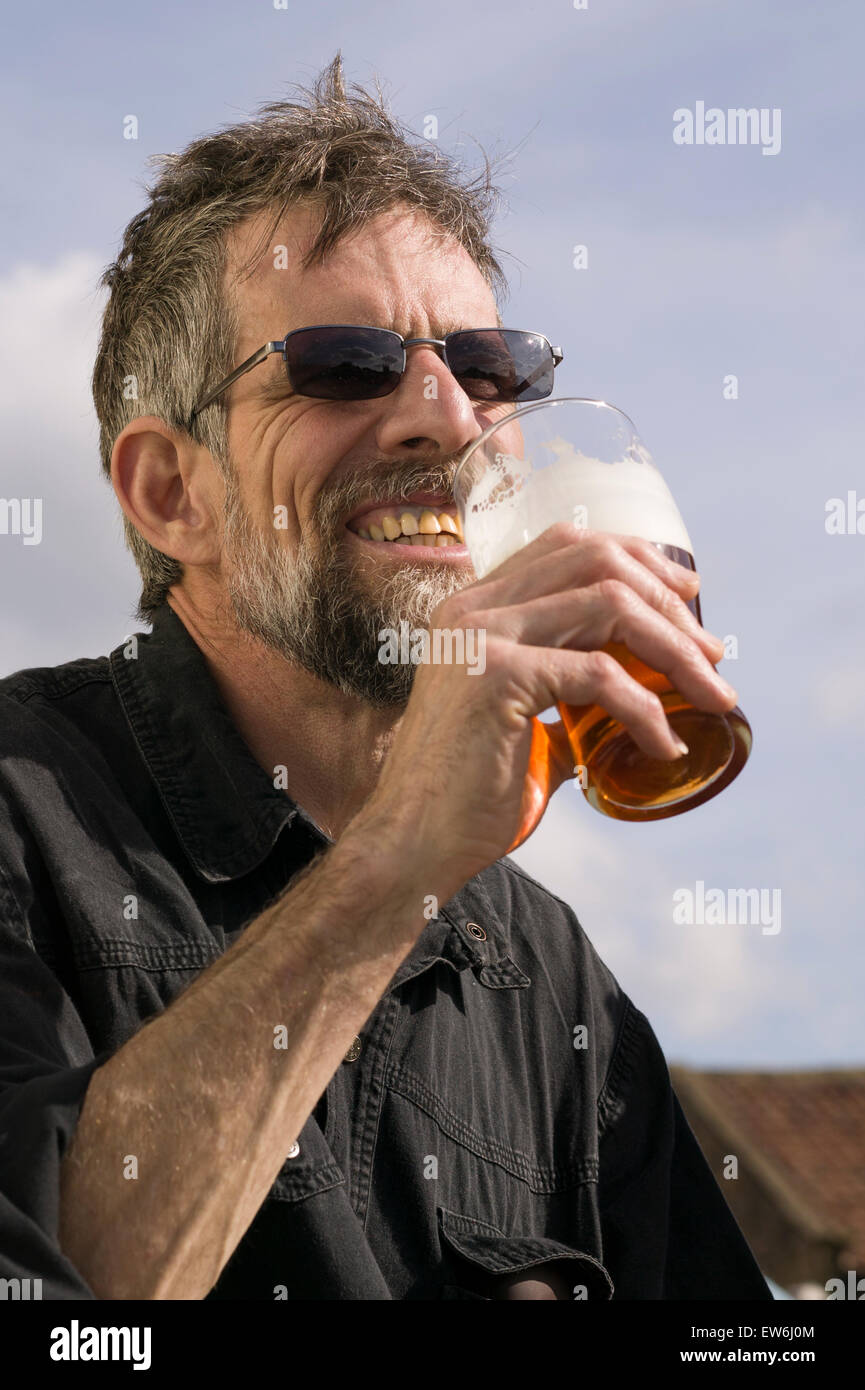 Un uomo con la barba beve una pinta di birra nella città di Helmsley in Inghilterra. Foto Stock