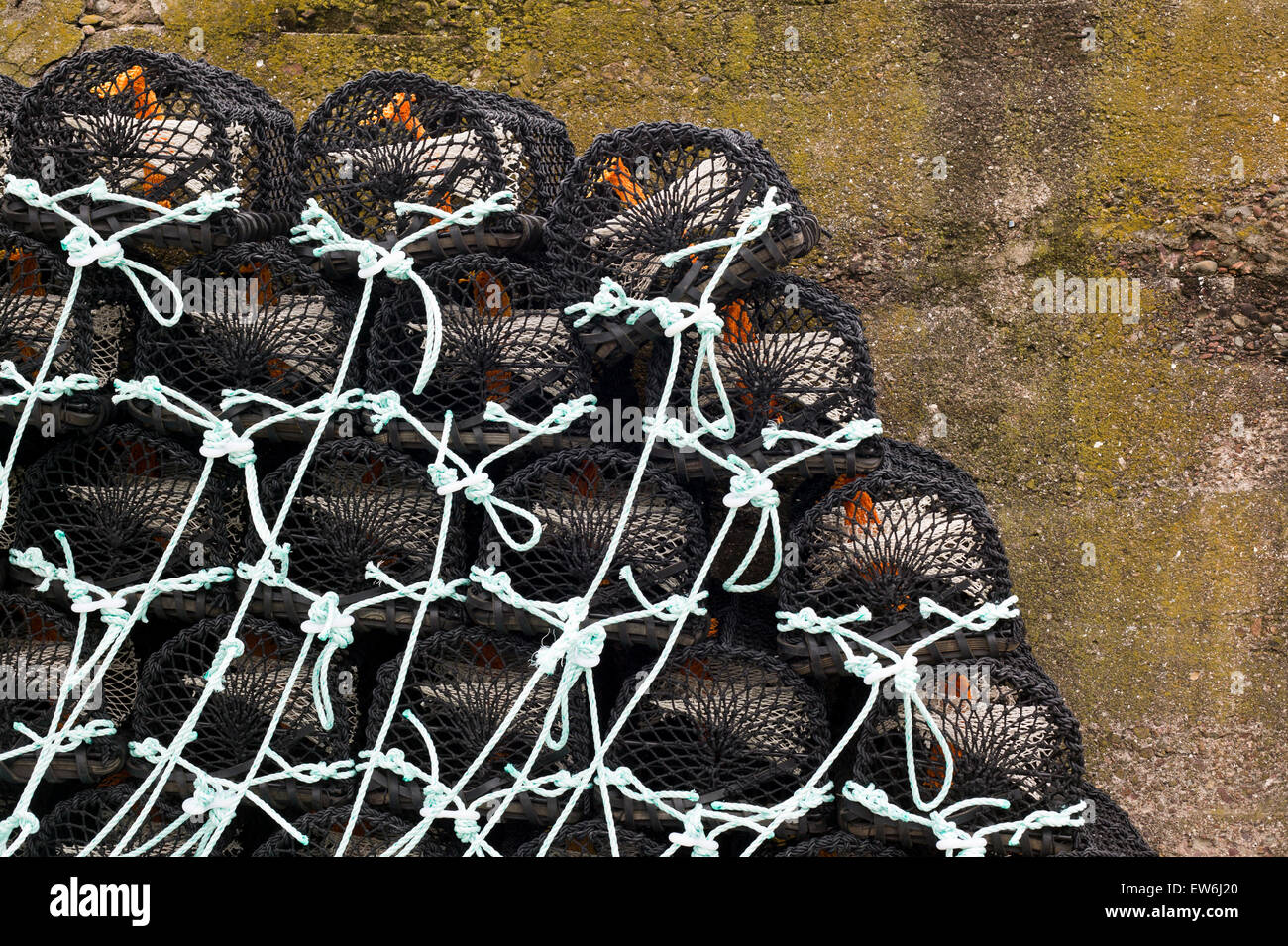 Trappole di aragosta impilate contro una parete in comune di Burnmouth in Inghilterra. Foto Stock