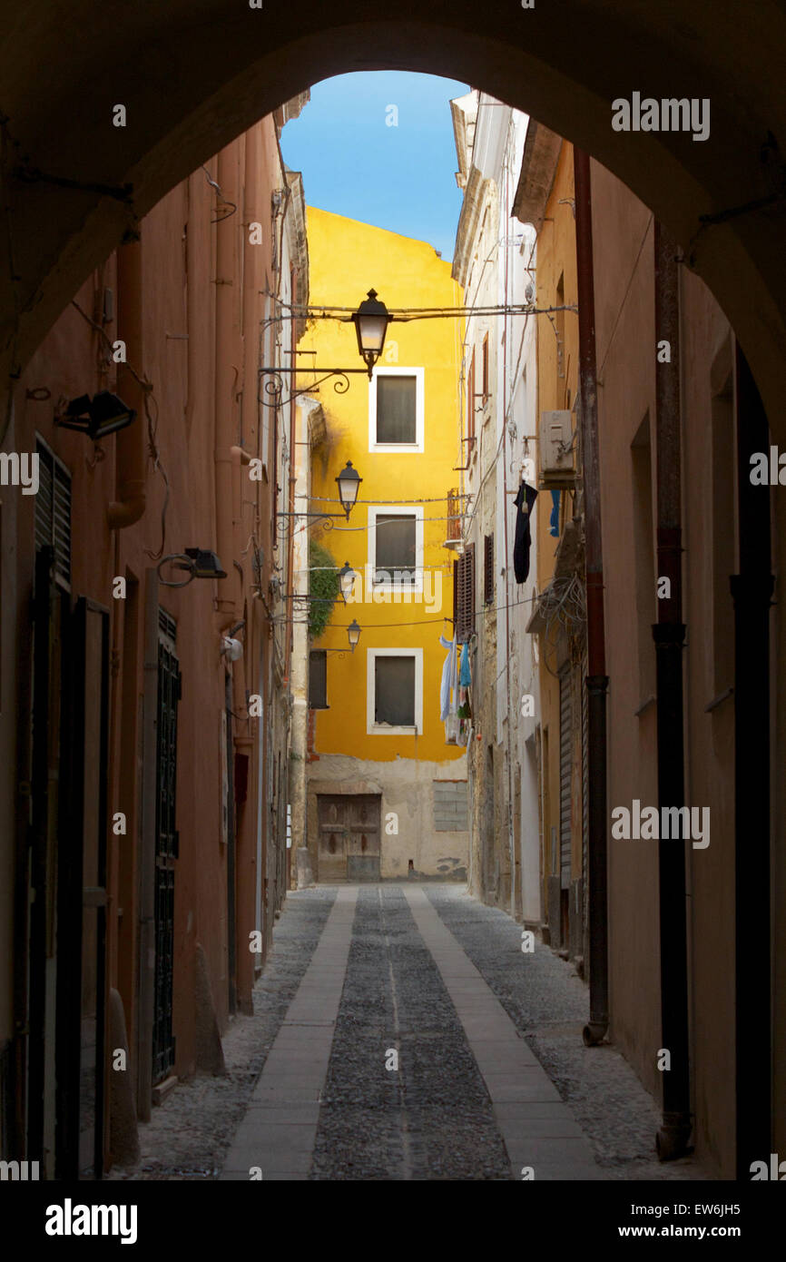 Via di passaggio che conduce ad un luminoso edificio giallo in Sassari Città Vecchia, Sardegna Foto Stock