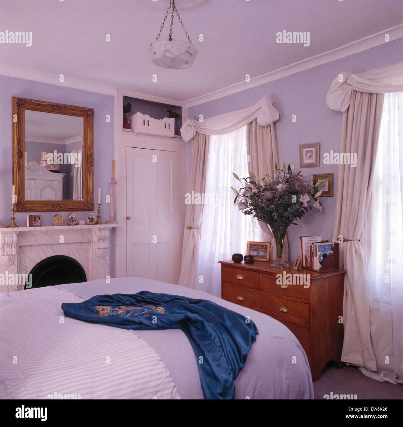 White swagged tende su windows negli anni novanta in camera da letto Foto Stock