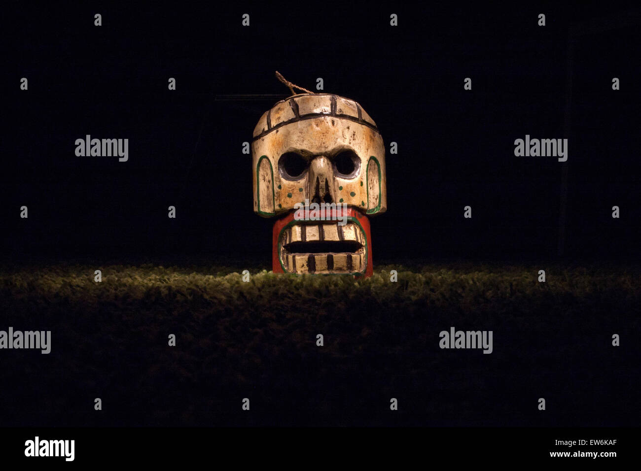 Maschera messicana di legno sul cranio su sfondo scuro Foto Stock