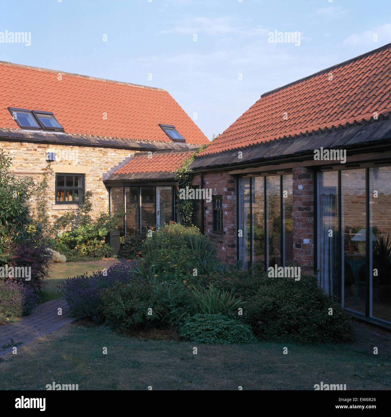 Letto di erbe nel cortile di fronte porte a vetro di conversione del granaio Foto Stock