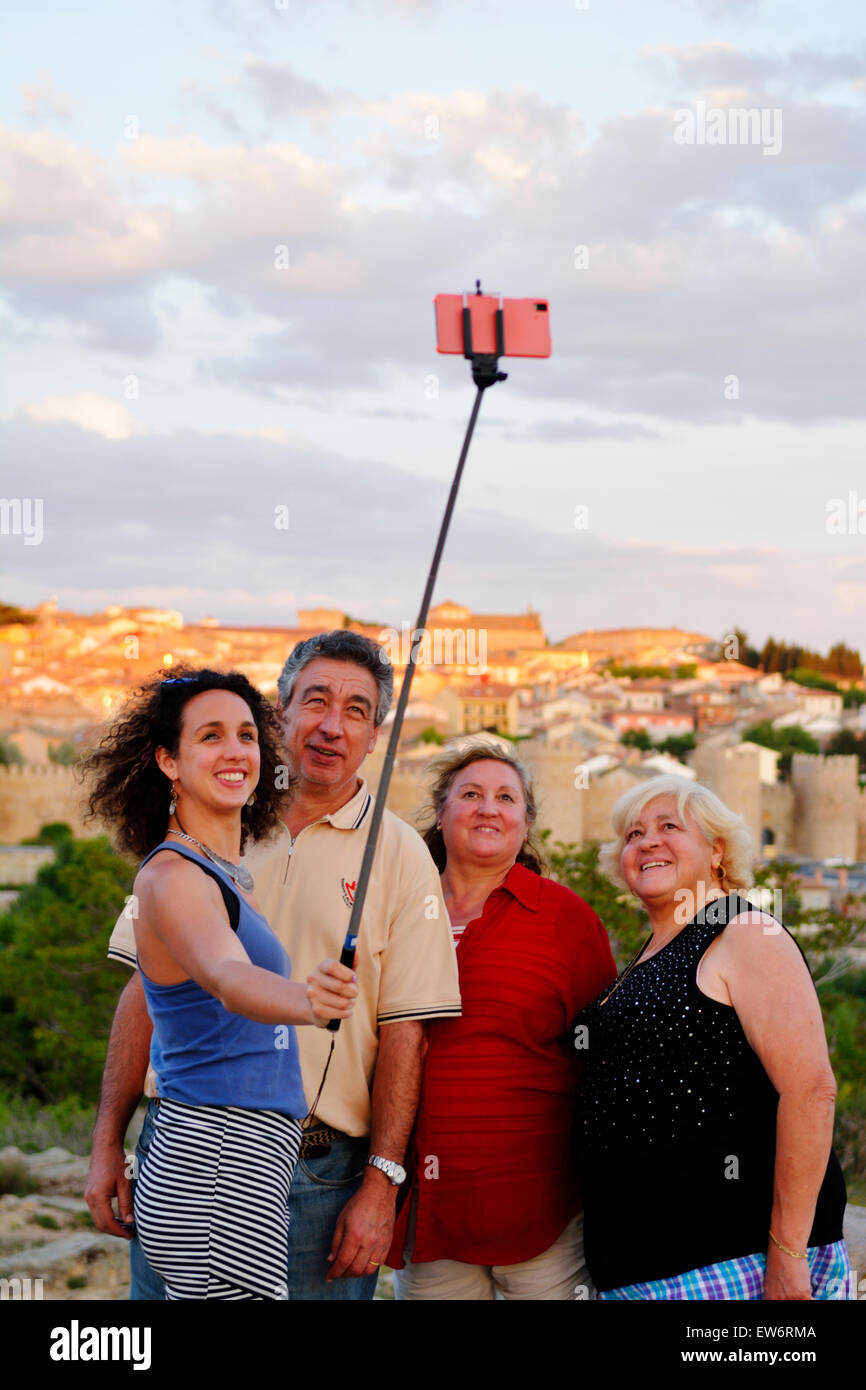 I turisti tenendo selfie foto accanto a Cuatro Postes (quattro montanti) viewpoint affacciato sulla città medievale di Avila, Spagna Foto Stock