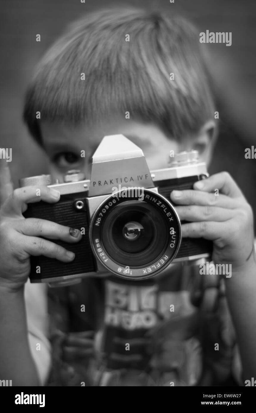 Un'immagine di mio figlio mi sta guardando mentre prendere una foto di me con una vecchia fotocamera a pellicola. Foto Stock
