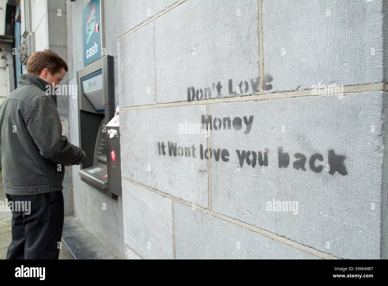 Graffiti ' non amano il denaro si preferirà love you back' su un muro di pietra di un edificio della banca in Dublino Irlanda Regno Unito Europa Foto Stock