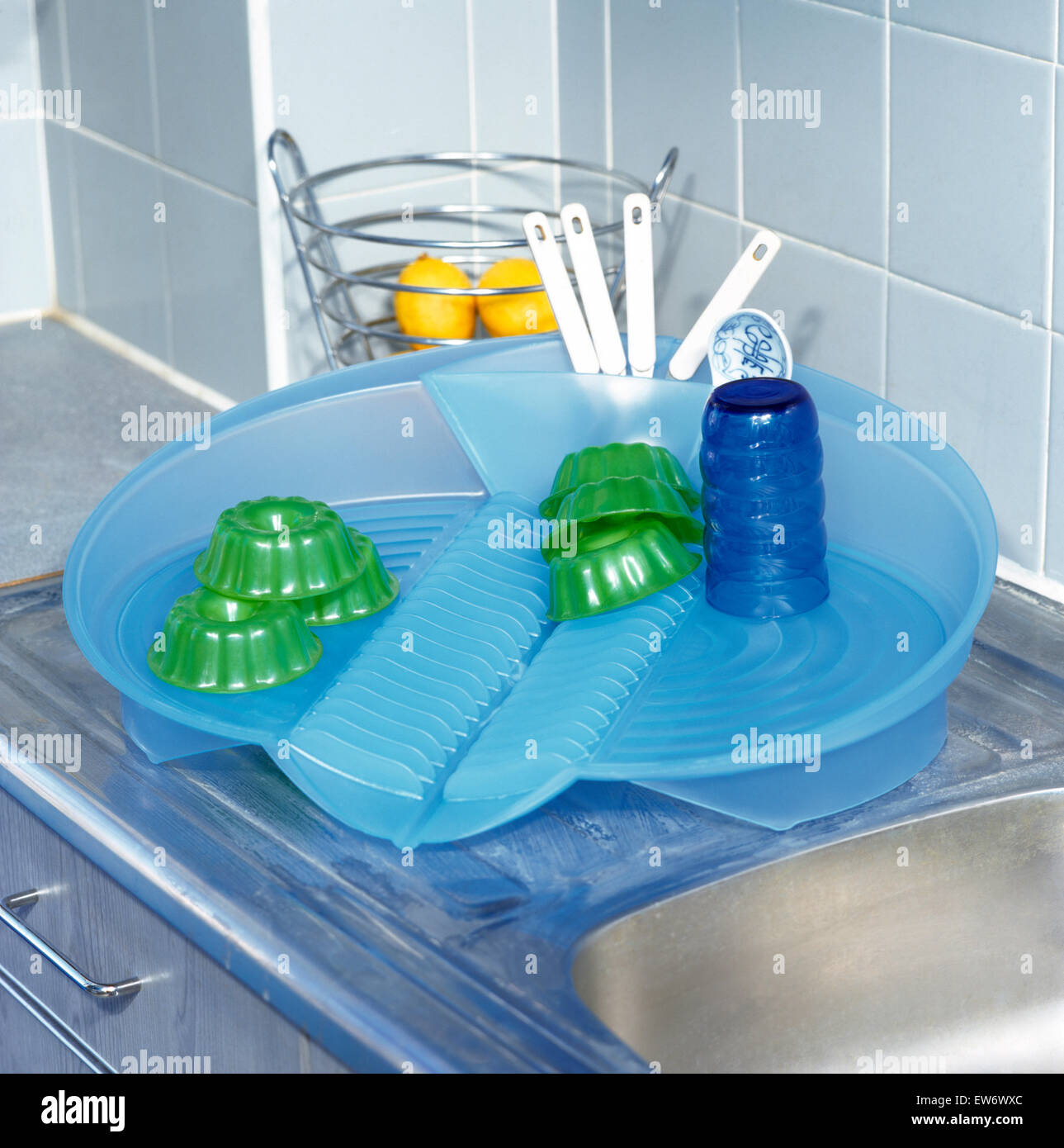 Close-up di un blu vassoio di plastica verde con piatti di plastica e un vetro blu Foto Stock