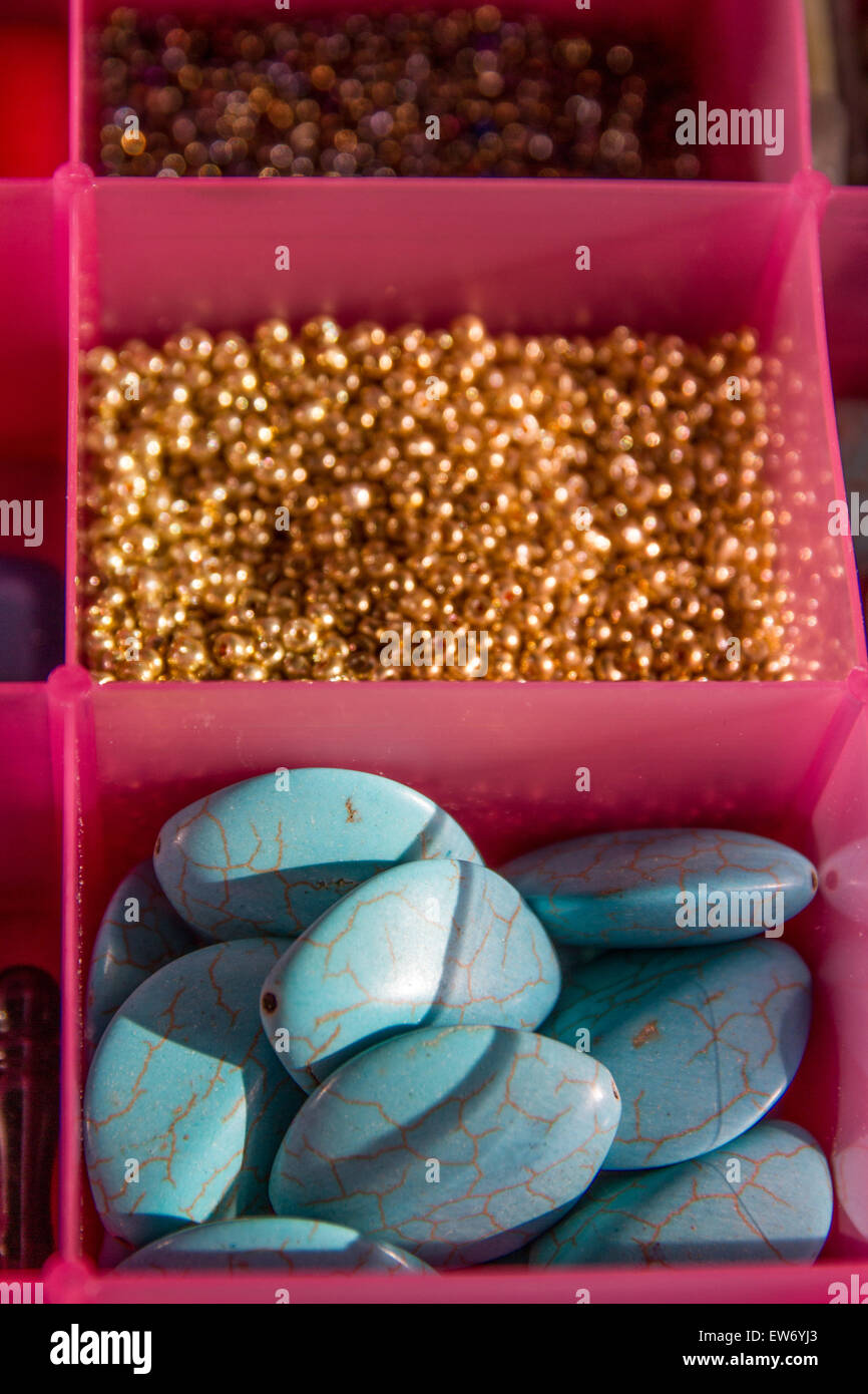 Perline colorate perle pietre in separati in contenitori di plastica per l'artigianato gioielli artistici. Foto Stock