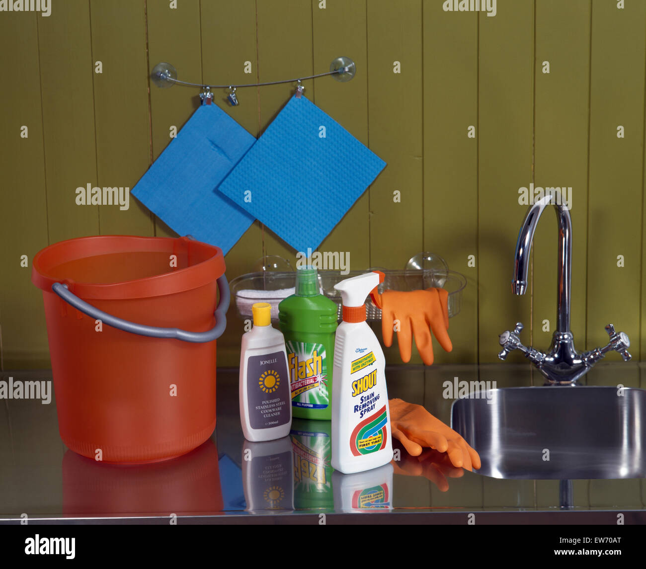 Close-up di prodotti per la pulizia con un arancione secchio di plastica e guanti di gomma Foto Stock