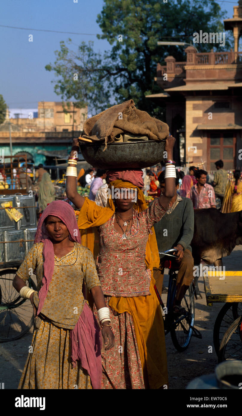 Le donne che trasportano i fasci e le passeggiate in un Indiano street per solo uso editoriale Foto Stock