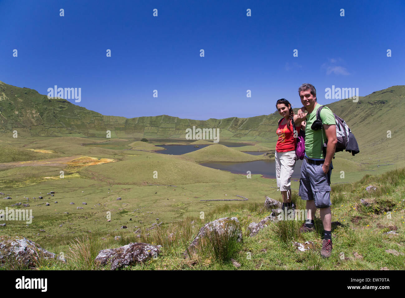Un paio di turisti che scattano una foto all'interno del cratere vulcanico dell'isola di Corvo mentre camminano verso il centro. Azzorre, Portogallo Foto Stock