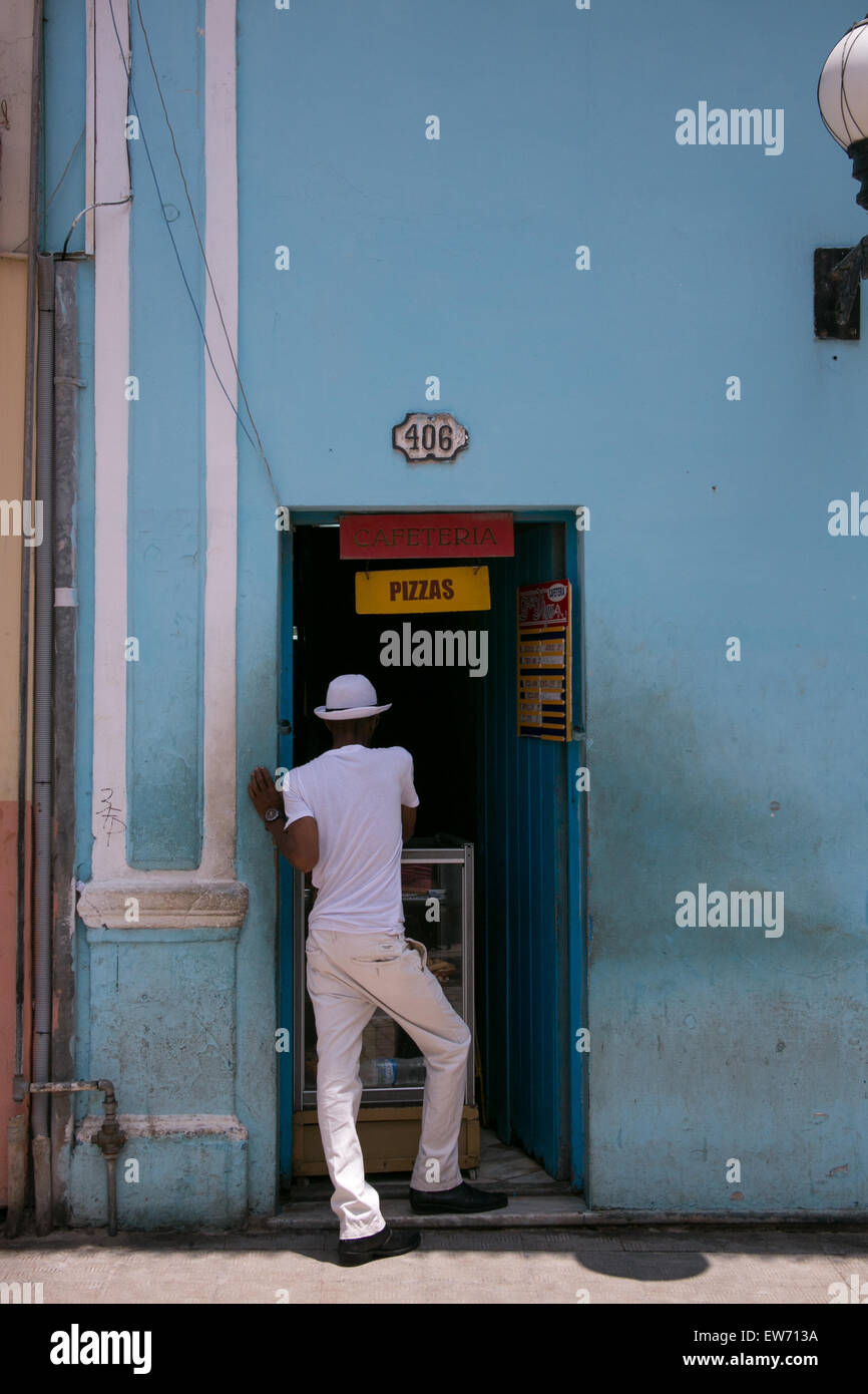 L'uomo acquisto di pizza da un riposo in un portale nella Vecchia Havana, Cuba. Foto Stock