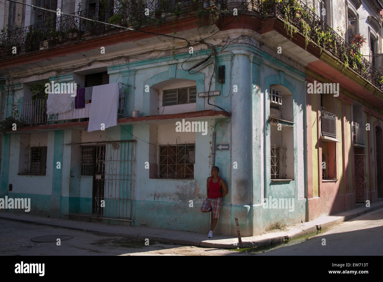 Uomo appoggiato a costruire in corrispondenza di un angolo di strada nella Vecchia Havana, Cuba. Foto Stock