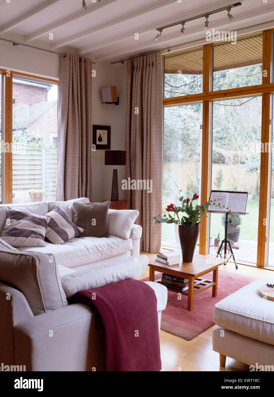 Divani bianchi nel soggiorno moderno interno con porte di vetro per il giardino Foto Stock