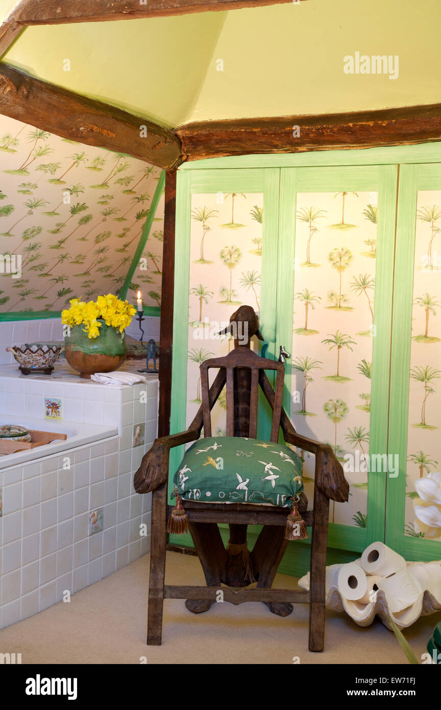 Insolita sedia in legno accanto a bagno nel paese giallo bagno con sfondo verde sulle antine Foto Stock