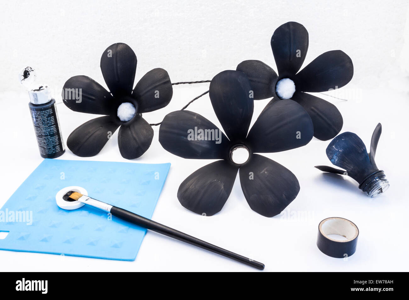 Il riciclaggio alcune bottiglie di plastica in fiori creazione embelishments nero Foto Stock