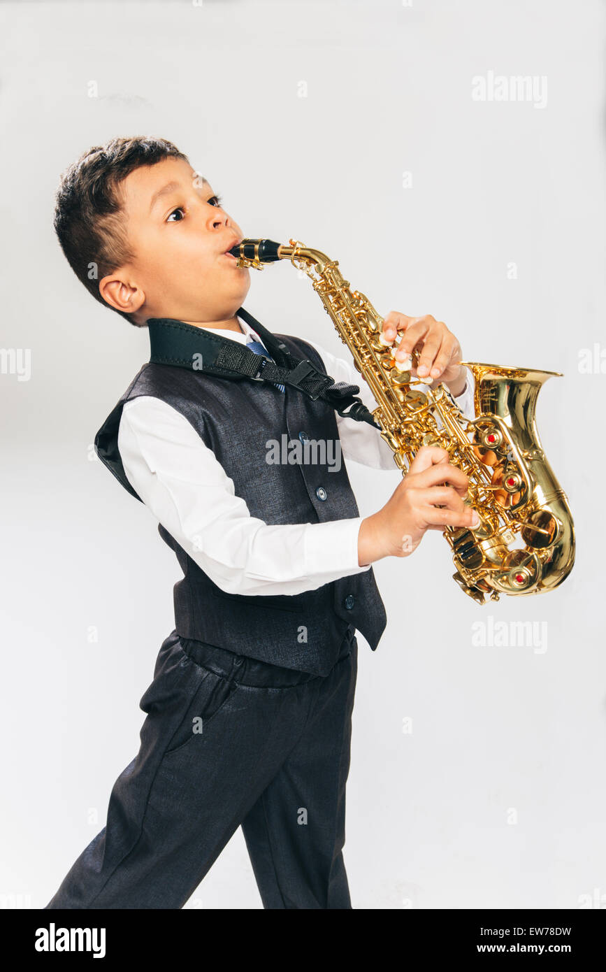 Sei anni vecchio ragazzo suona il sassofono in studio Foto Stock
