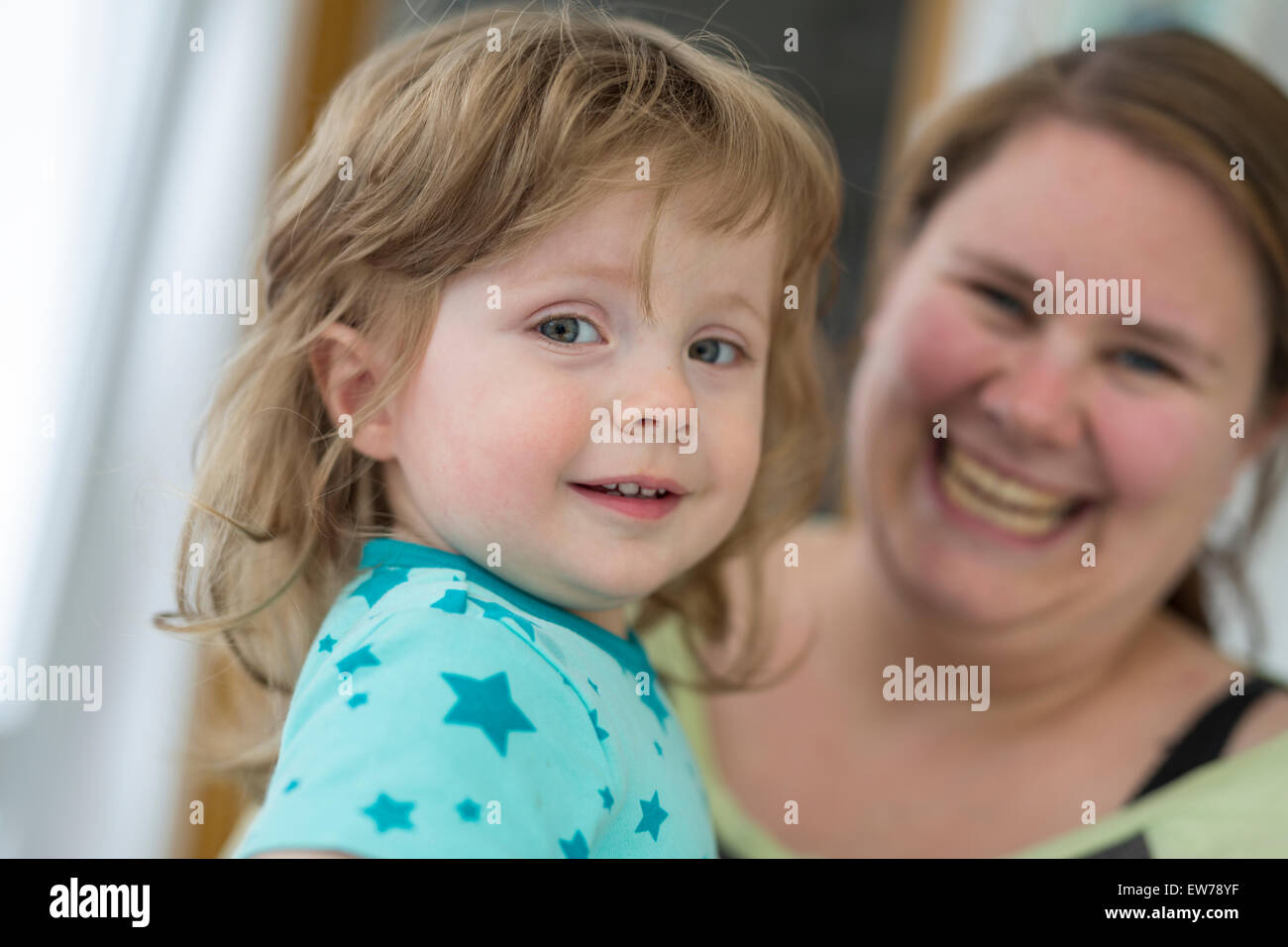 Bambina nella madre di braccia Foto Stock
