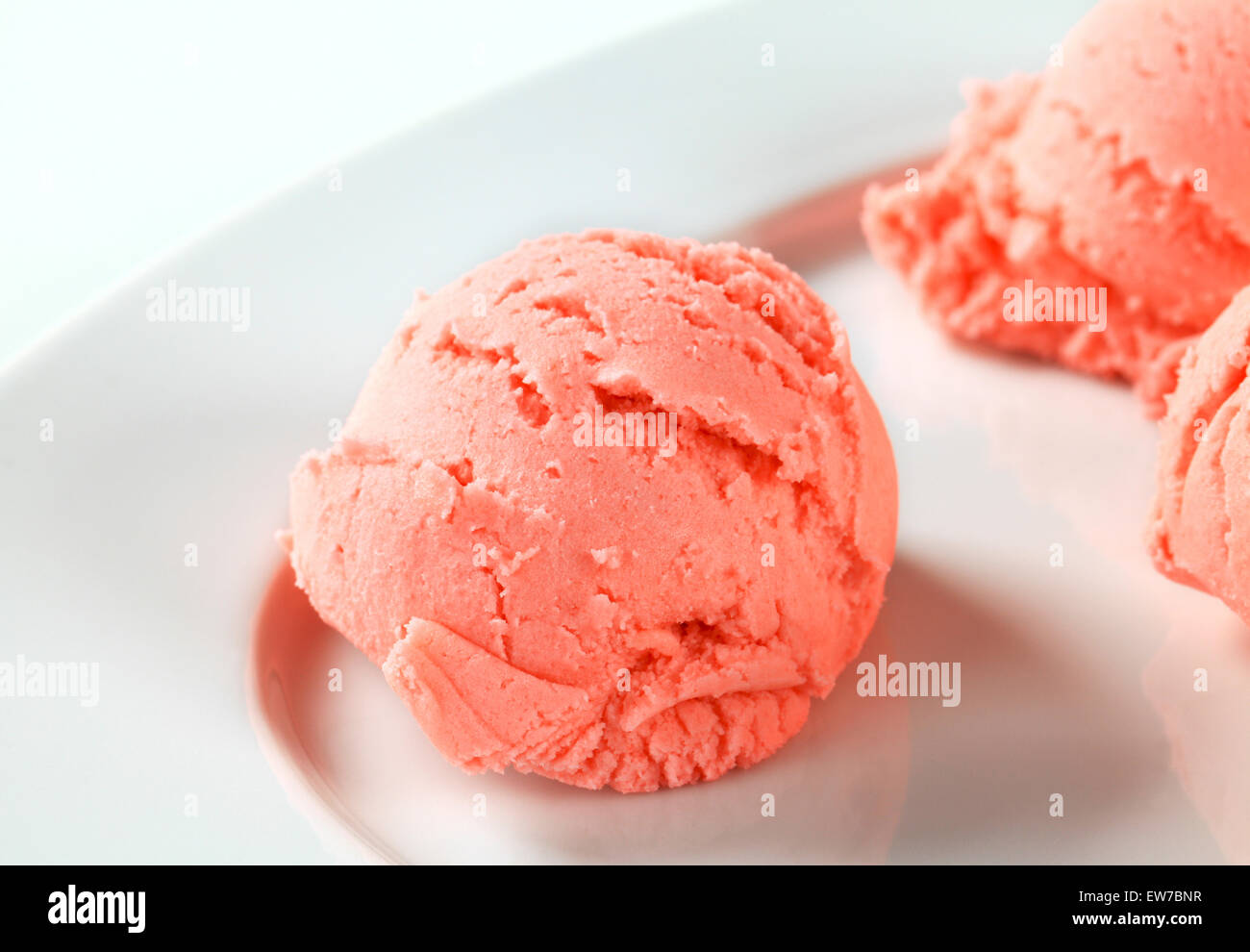 Palline di gelato alla fragola su piastra Foto Stock