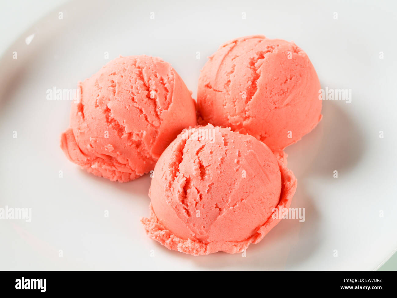 Palline di gelato alla fragola su piastra Foto Stock