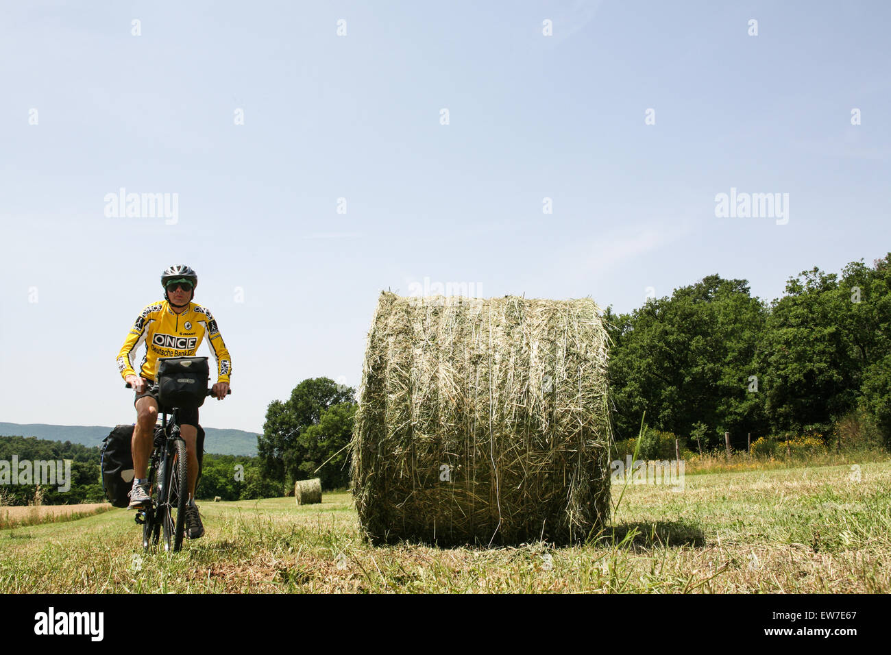 Me, un turista inglese, escursioni in bicicletta attraverso i campi di  grano su un caricato touring in bicicletta in campagna vicino a Siena in  Toscana. L'Italia. Giugno. Modello rilasciato Foto stock -