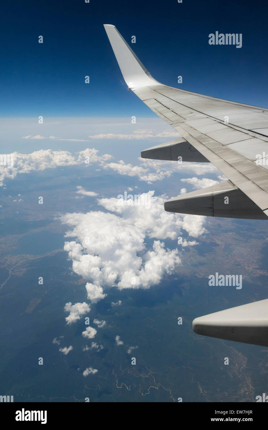 Ala di un aeroplano sopra le nuvole nel cielo Foto Stock