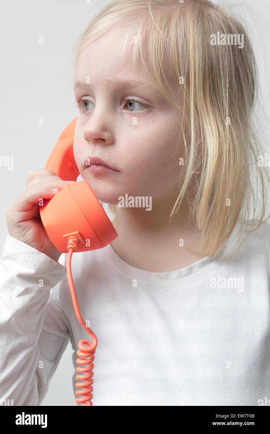 Ragazza che parla su un telefono tradizionale Foto Stock