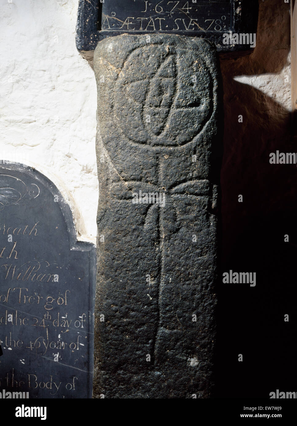 Cross-colonne scolpite nella chiesa Llanbadrig, Anglesey, forse un inizio di grave marker con una ruota-croce al di sopra di un lineare a croce latina. Pesce & palm simboli? Foto Stock