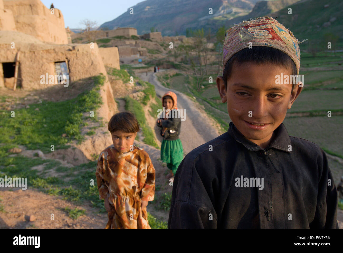Un ragazzo tagiko e un paio di ragazze in corrispondenza del bordo del villaggio tagiko di Dera Jawal, alla base della banda-e gamma di Baba, Herat Prov Foto Stock