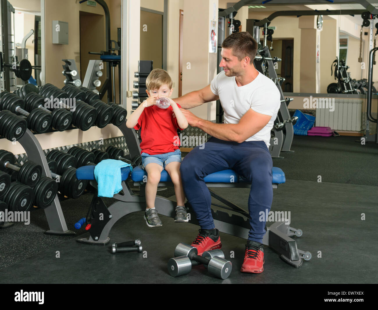 Il Papa mostra piccolo figlio come sollevare pesi nella palestra Foto Stock