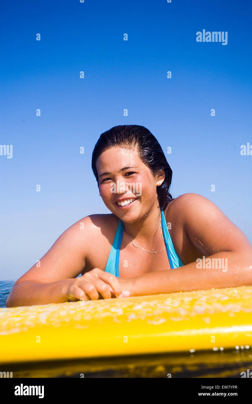 Un surfer girl sorrisi nell'acqua. Foto Stock