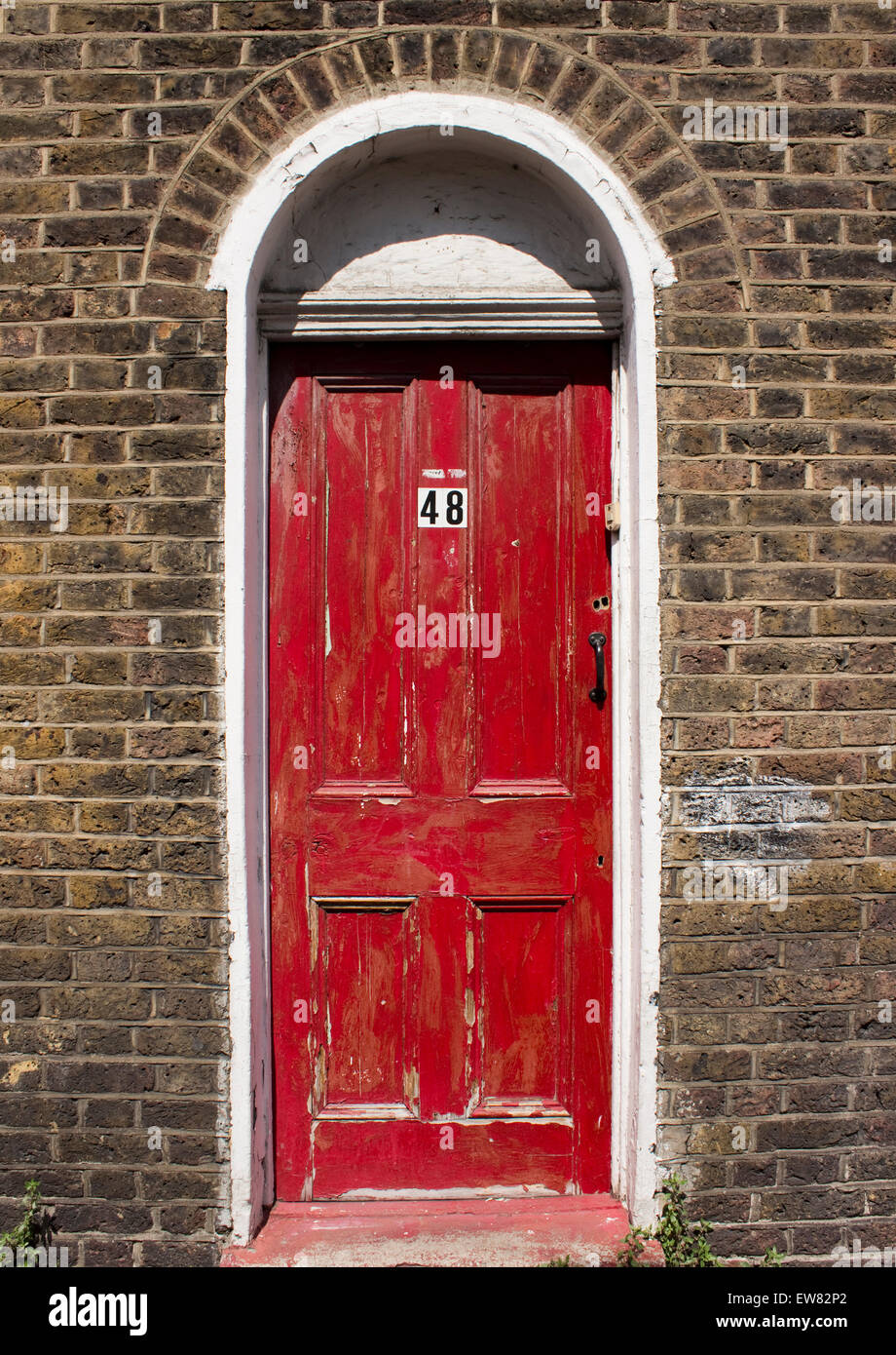 Vecchia porta rossa sulla costruzione di mattoni Foto stock - Alamy