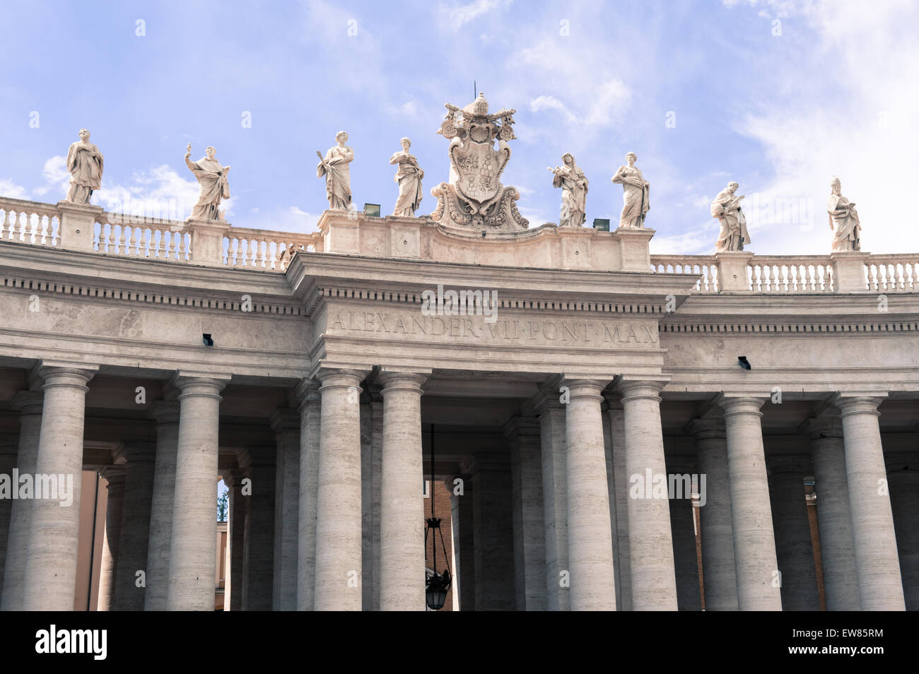 Parte del colonnato con statua e simbolo del vaticano in piazza San Pietro a Roma, Italia Foto Stock