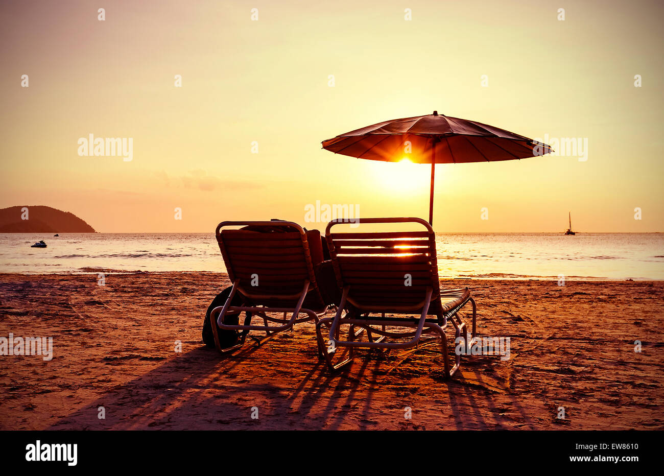 Vintage instagram stilizzata sedie a sdraio e ombrellone al tramonto. Concetto per vacanze e relax. Foto Stock