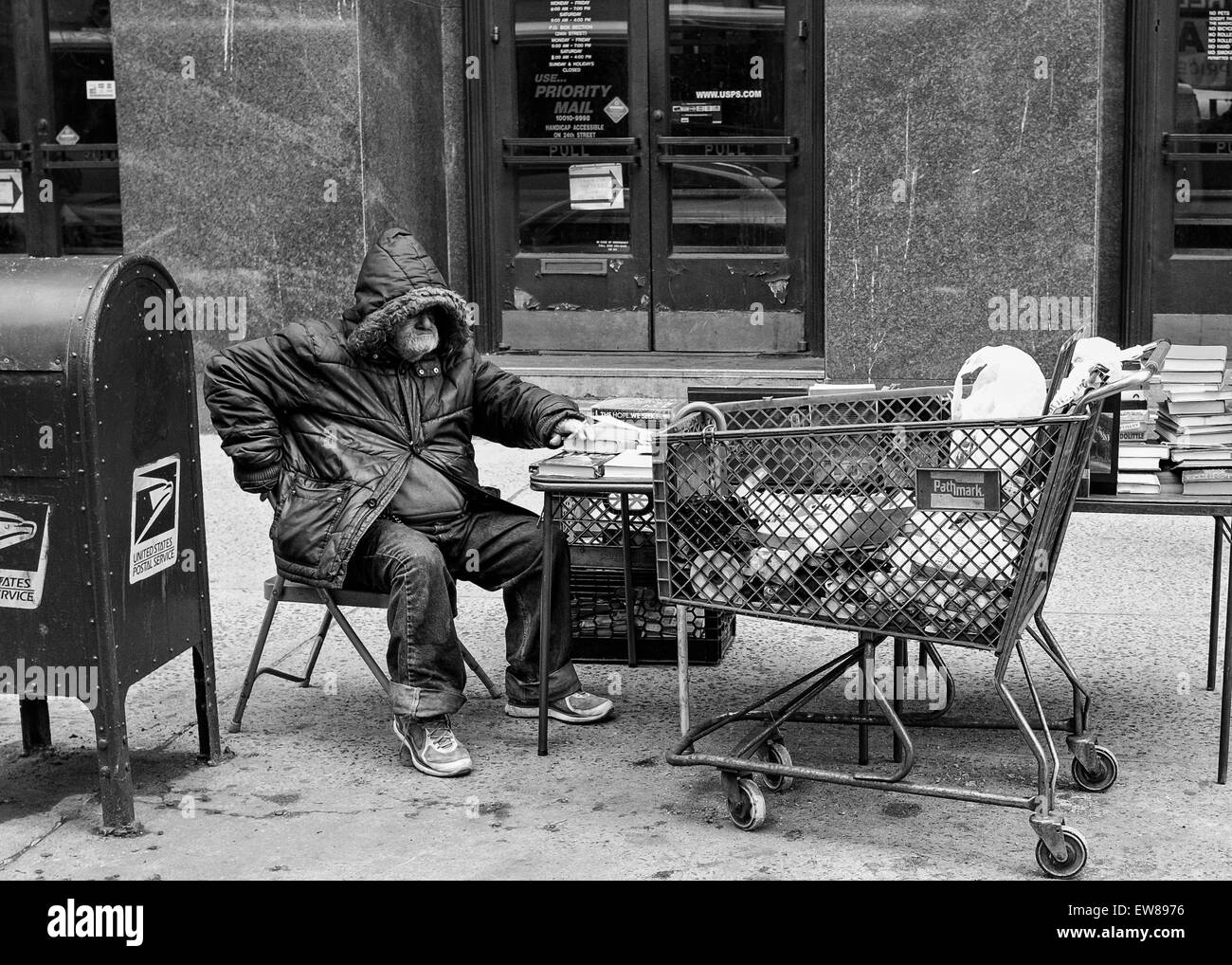 Senzatetto uomo con carrello vendita libri di fronte Gramecy Park , New York , post office Foto Stock