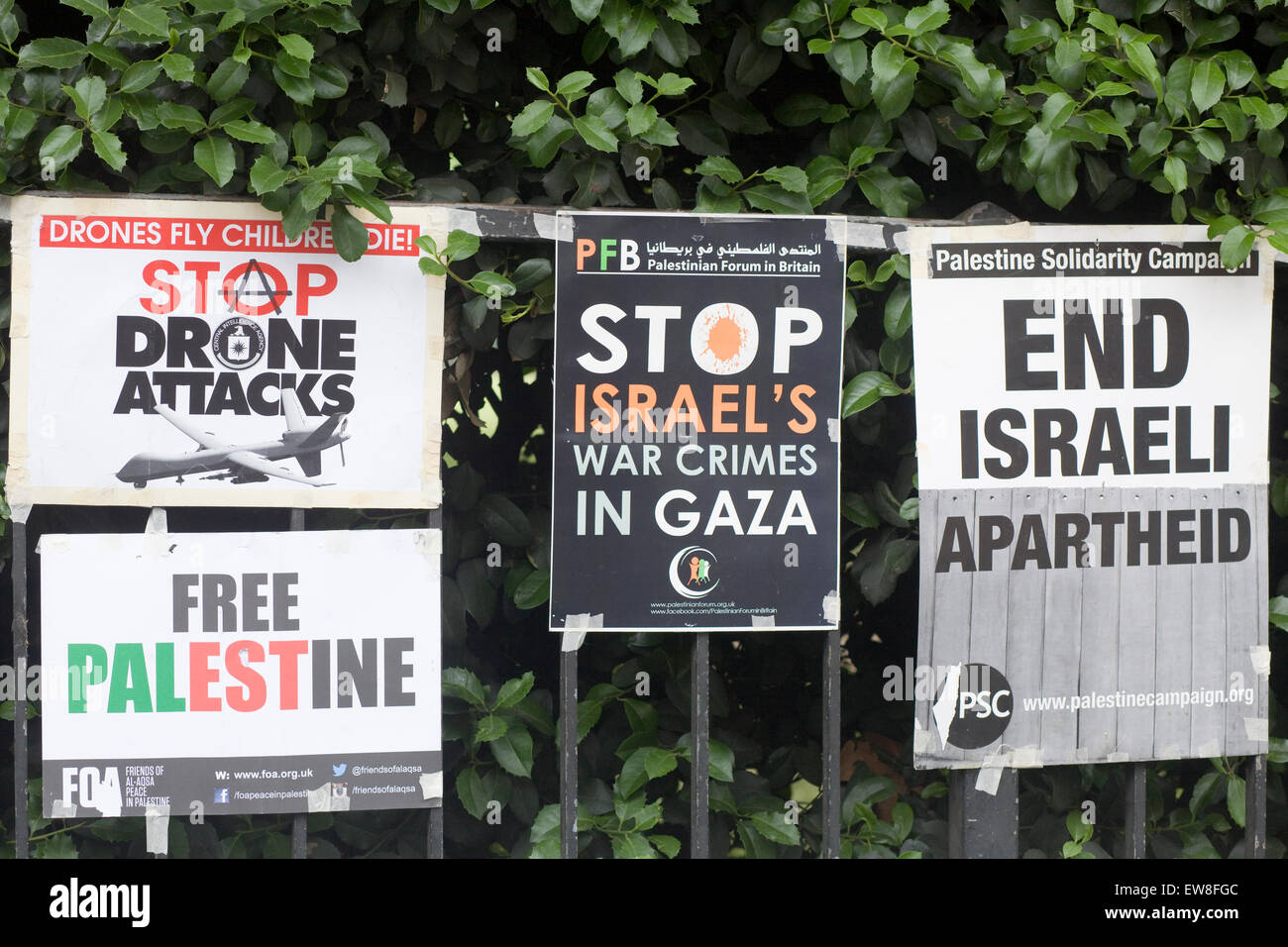 Fermare i crimini di guerra contro la striscia di Gaza e la Palestina manifesti attaccati alla ringhiera a Londra Foto Stock