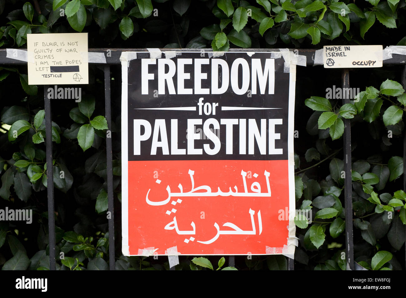 Fermare i crimini di guerra contro la striscia di Gaza e la Palestina manifesti attaccati alla ringhiera a Londra Foto Stock