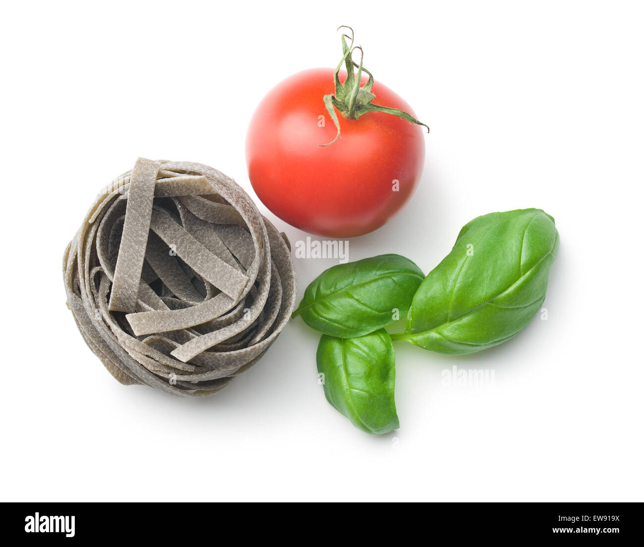 Tagliatelle con pomodoro e basilico foglie su sfondo bianco Foto Stock