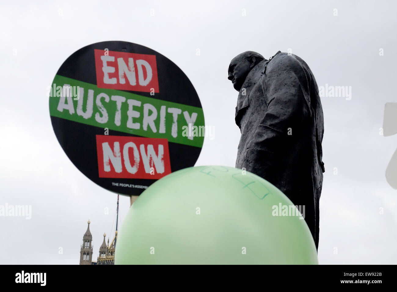 Un manifestante detiene una targhetta accanto il Churchill della statua lettura ' fine austerità ora ' Foto Stock