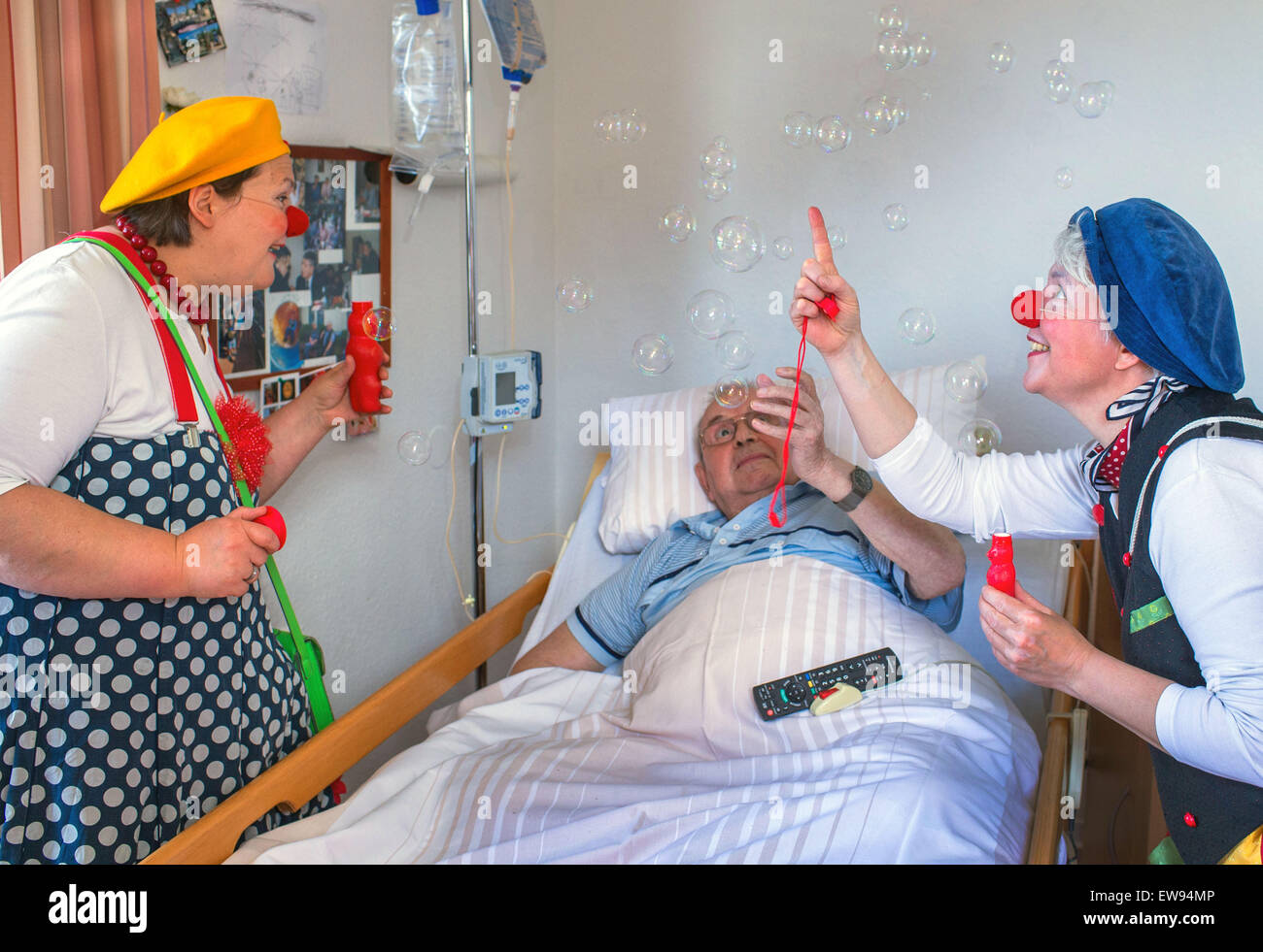Schwerin, Germania. 05 Giugno, 2015. Ospedale clown "bene" (Ines Vowinkel, R) e 'Kiki' (Kerstin Daum) sorpresa Guenther Piehl con bolle di sapone durante un tour attraverso i reparti di assistenza infermieristica del 'Augustenstift' nursing home in Schwerin, Germania, 05 giugno 2015. I clown hanno visitato i pazienti dementi e le persone che richiedono una cura una volta al mese per gli ultimi due anni. Foto: Jens Buettner/dpa/Alamy Live News Foto Stock