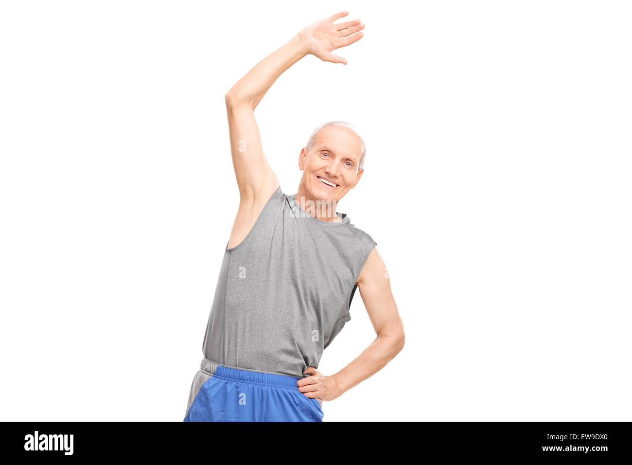 Senior attivo facendo esercizi di stretching e guardando la telecamera isolata su sfondo bianco Foto Stock