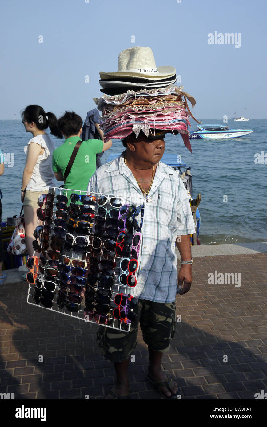 Un maschio beach venditore la vendita di occhiali da sole e cappello da sole in Pattaya Thailandia Foto Stock