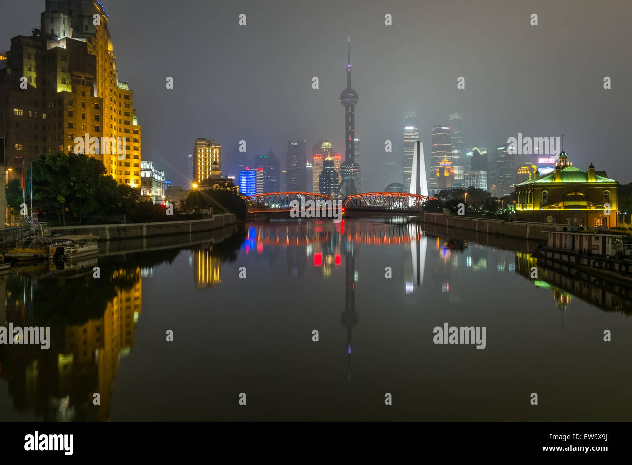 Città illuminata e il ponte sull'acqua Foto Stock