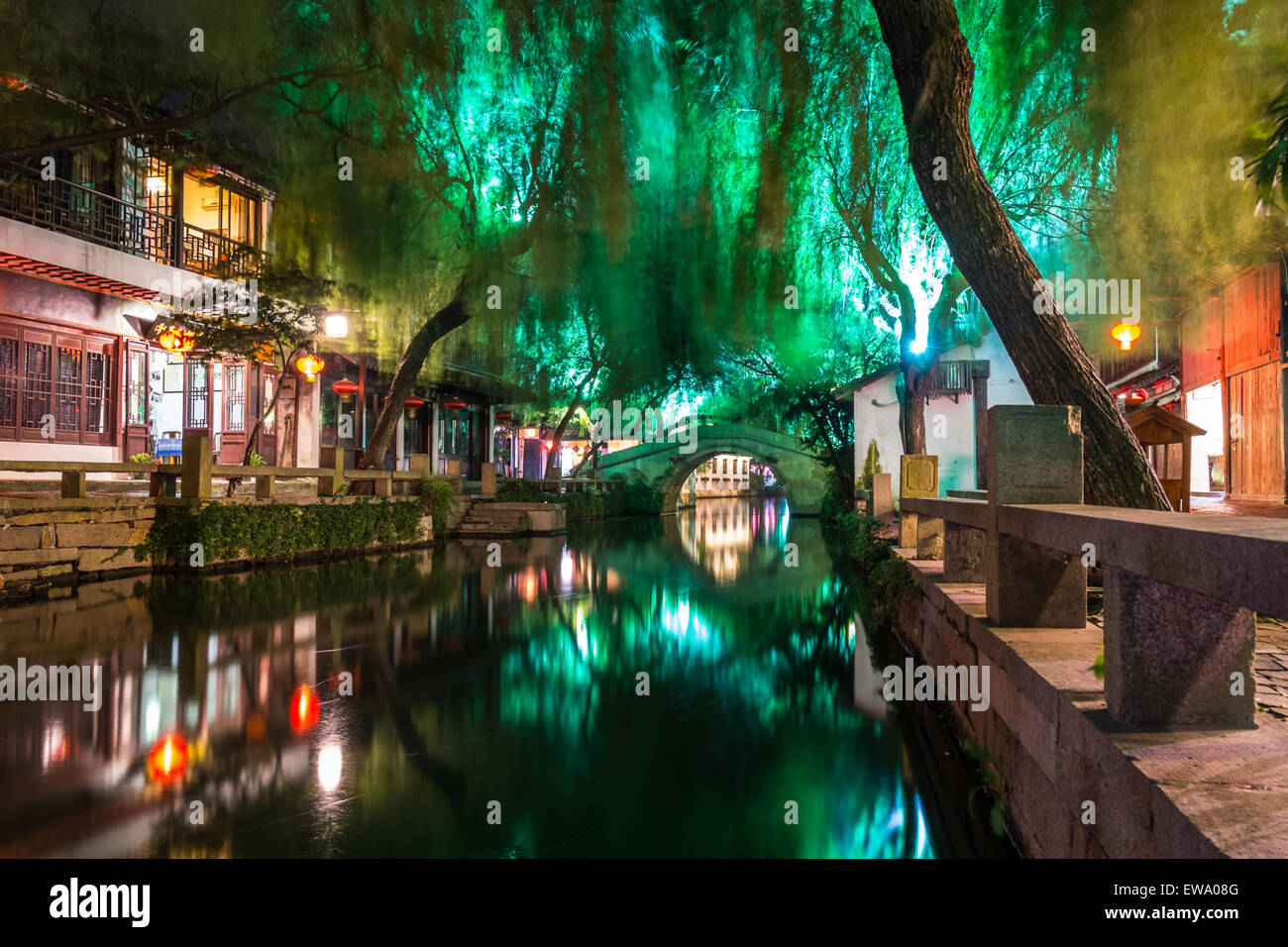 Vista notturna delle tradizionali case cinesi illuminate, del canale e del ponte di pietra nella storica e panoramica cittadina sull'acqua di Zhouzhuang, in Cina Foto Stock